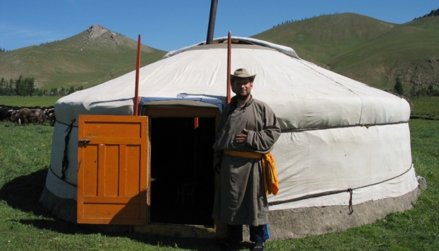 Grzegorz Gawlik w tradycyjnym stroju del przed jurtą, Mongolia.